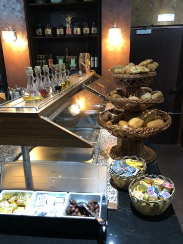 a buffet with bowls of food on a counter at Hotel Poseidon in Bayreuth