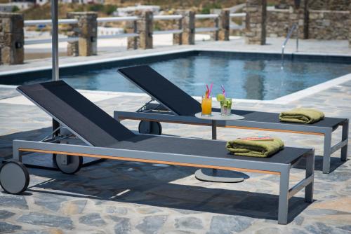 a table and bench next to a swimming pool at Alkistis Beach Hotel - Adults Only in Agios Stefanos