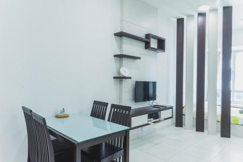 a dining room with a table and chairs and a television at Shawn Akademic Suites Pool View @ Mount Austin in Johor Bahru