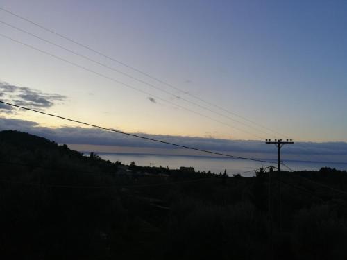 a sunset on a hill with a view of the ocean at Monika Lefkada in Tsoukaladhes