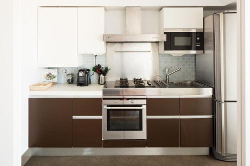 a kitchen with a stove and a refrigerator at Skyscraper Riverview Lisbon with Indoor Pool in Lisbon
