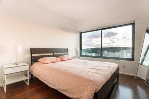 En eller flere senge i et værelse på Skyscraper Riverview Lisbon with Indoor Pool