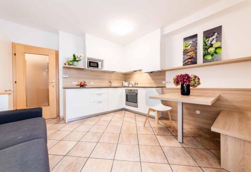 a living room with a table and a kitchen at Pixner Apartments in Bolzano