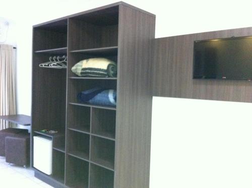 a book shelf with a tv in a room at Termas Park Hotel in Gravatal