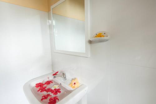 a bathroom with a sink with red flowers on it at Ashiyana Hotel in Mirissa