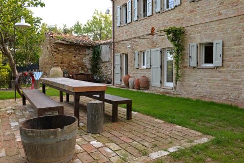 a picnic table and bench in front of a building at Castello di Granarola Relais - Adults Friendly - in Gradara