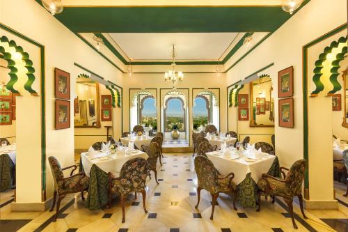 a dining room with white tables and chairs at Shiv Niwas Palace by HRH Group of Hotels in Udaipur