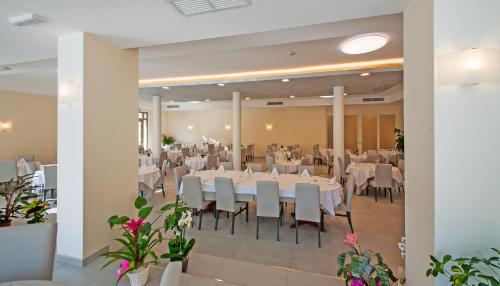 a banquet hall with white tables and white chairs at Risthotel Airport in Fogliano Redipúglia