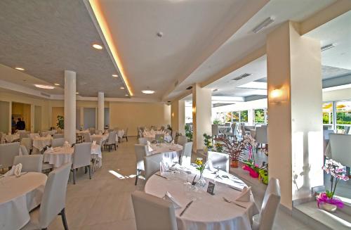 a dining room with white tables and white chairs at Risthotel Airport in Fogliano Redipúglia