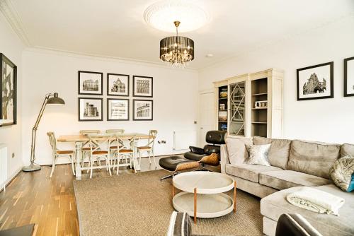 ein Wohnzimmer mit einem Sofa und einem Tisch in der Unterkunft JOIVY Luxury 2 and 3 bed flats on Historic George Street in Edinburgh