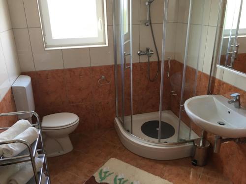 a bathroom with a shower and a toilet and a sink at Apartmani Marija Klimno A in Klimno
