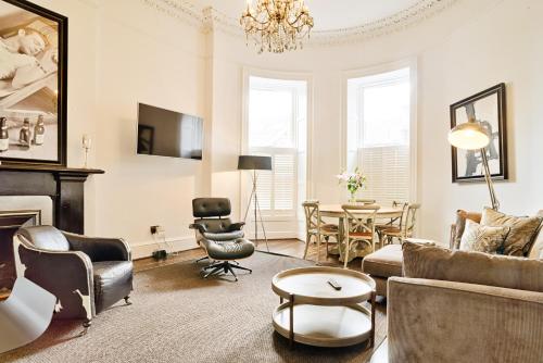 a living room with a couch and a table at JOIVY Luxury Flats on George Street in Edinburgh