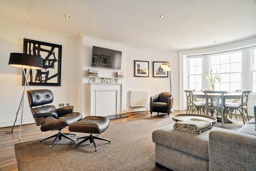 a living room filled with furniture and a large window at ALTIDO Luxury George St Apartments in Edinburgh