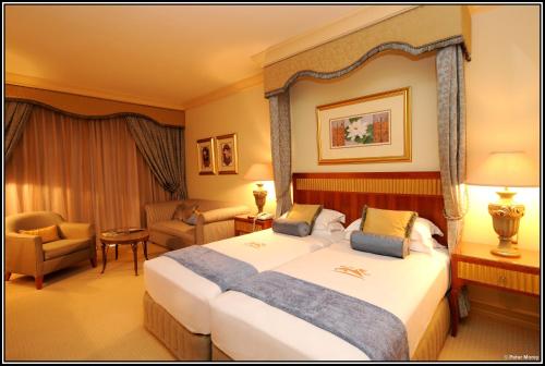 a hotel room with a large bed and a chair at Peermont D'oreale Grande at Emperors Palace in Kempton Park