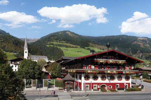 a building in a town with mountains in the background at Hotel Flatscher in Stuhlfelden