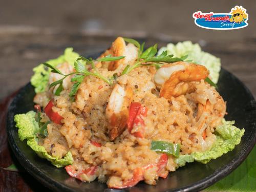 a black plate of food with shrimp and rice at Casa Grande Surf in Guachaca