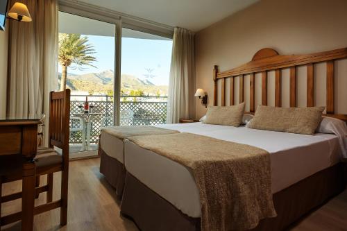 a bedroom with a bed and a large window at Villa Flamenca in Nerja