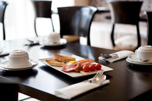 a plate with sausage and toast on a table at Tara Lodge in Belfast