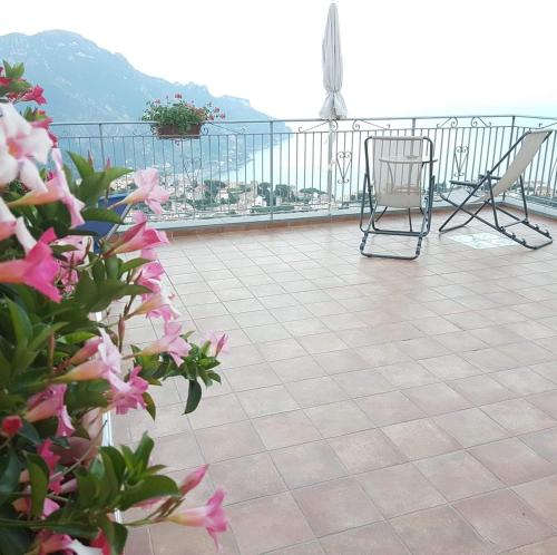 a patio with chairs and flowers on a balcony at B&B Oliva in Scala