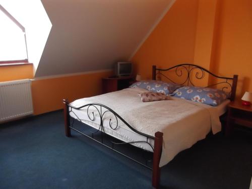 a bedroom with a bed in an orange room at Penzion Lesna in Vysoke Tatry - Tatranska Lesna