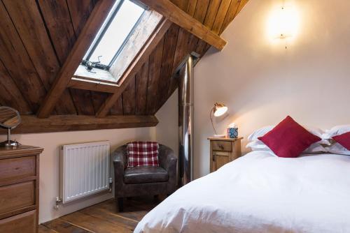 1 dormitorio con 1 cama y 1 silla en Cottage 2 New Yatt Farm, en Witney