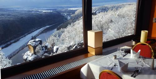 a dining room with a view of a river at Berghotel Bastei in Lohmen