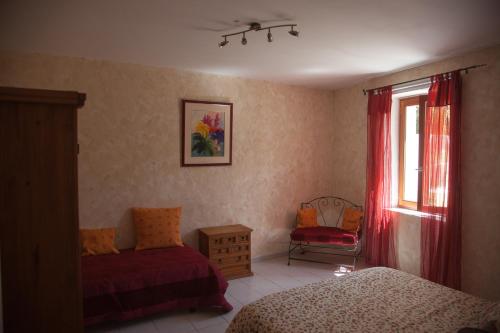 a bedroom with two beds and a window and a chair at LE CLOS DES COLVERTS in Campagne-sur-Aude