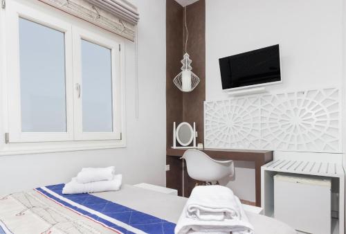 a bedroom with a bed and a desk and a tv at Villa Ilias in Firostefani