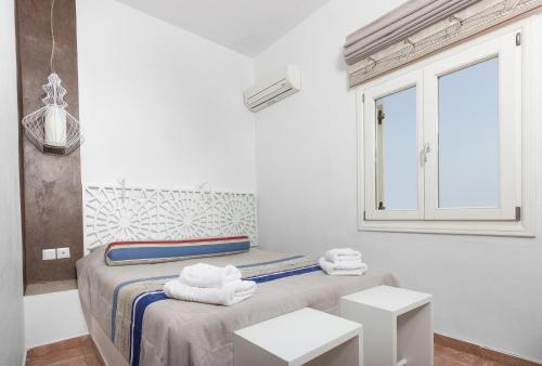 a white room with a bed with towels on it at Villa Ilias in Firostefani