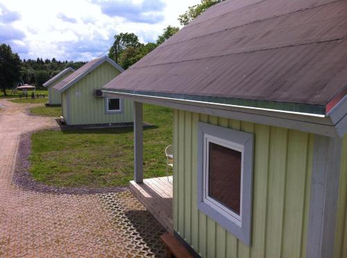 a small green building with a brown roof at Valaste Puhkeküla in Kohtla-Järve