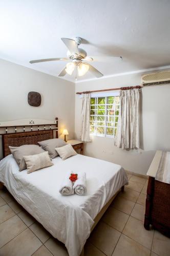 a bedroom with a large bed with a ceiling fan at Villas Chiara Punta Cana in Punta Cana