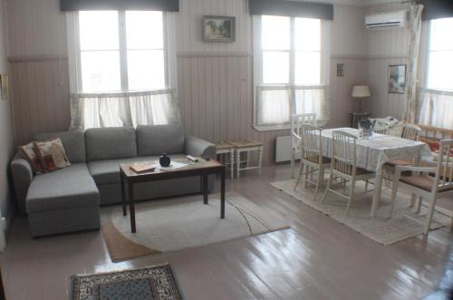 ein Wohnzimmer mit einem Sofa und einem Tisch in der Unterkunft Slottsbädden in Tammisaari