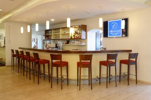 a bar in a restaurant with red stools at Hotel & Restaurant Christkindlwirt in Steyr