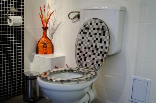 a bathroom with a toilet with a black and white seat at Casa Preto E Branco in Moieciu de Jos