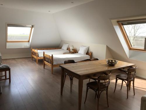 1 dormitorio con 1 cama, mesa y sillas en Boerderij de Waard, en Anna Paulowna
