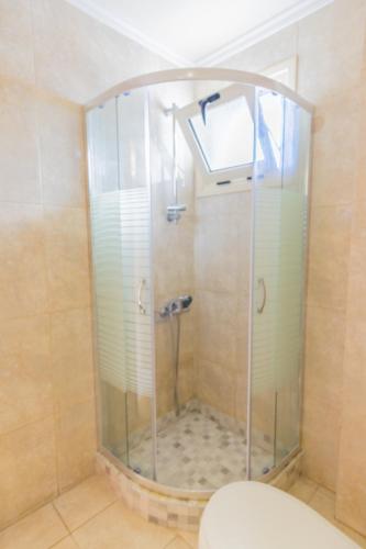 a shower with a glass door in a bathroom at Pela Sofia in Stalís