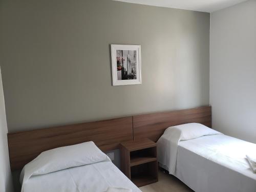 ein Zimmer mit zwei Betten und einem Bild an der Wand in der Unterkunft Executive Plaza Hotel in Núcleo Bandeirante