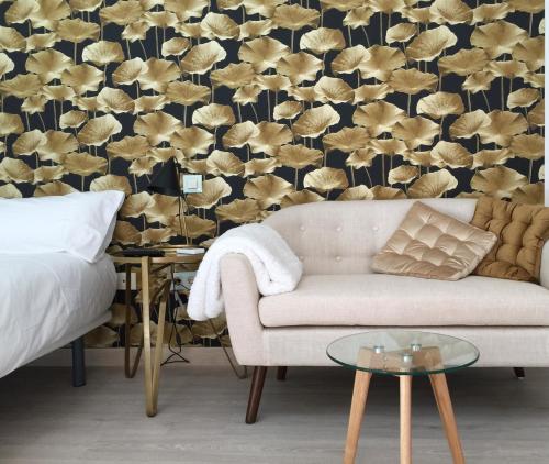 a living room with a couch and a wall with a wallpaper at Puerta Trujillo in Plasencia