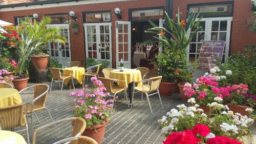 an outdoor patio with tables and chairs and flowers at The Carre Arms Hotel & Restaurant in Sleaford