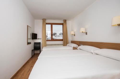 a hotel room with two beds and a window at Hotel Catalunya Ski by Nexta in Pas de la Casa