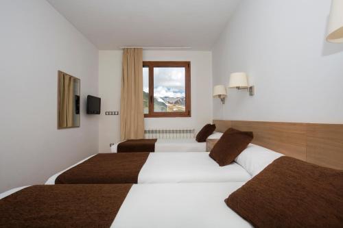 a hotel room with two beds and a window at Hotel Catalunya Ski in Pas de la Casa