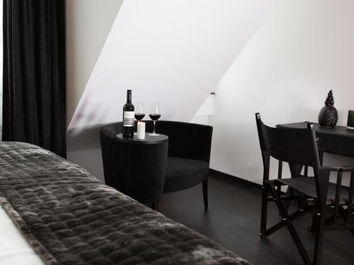 a bedroom with a table with two glasses of wine at Boutique Hotel K7 in Bad Nauheim