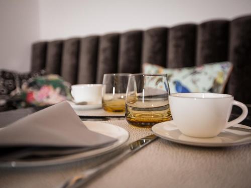 a table with two glasses and a cup and a coffeeucer at Boutique Hotel K7 in Bad Nauheim