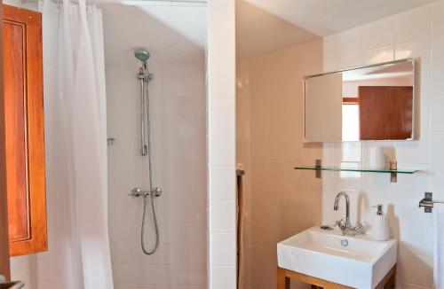 ein Badezimmer mit Dusche und Waschbecken in der Unterkunft Casa da Manta - Palheiro in Fajã da Ovelha