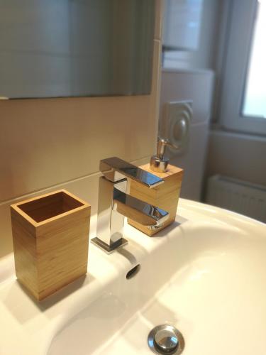 a bathroom sink with a faucet and a wooden box at Apartment U - relax in Leipzig