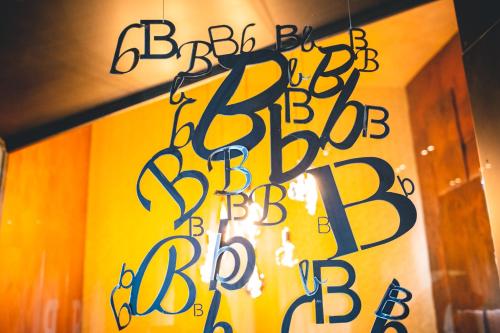 a sign that says big brother bebidbid hanging from a wall at Base Hotel in Noventa di Piave