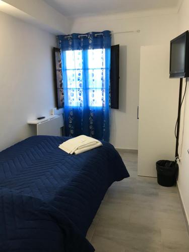 a bedroom with a blue bed and a blue curtain at NN Guest House in Coimbra