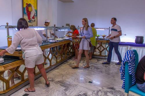 a group of people standing in a kitchen preparing food at Hotel Dreams Beach in Hammam Sousse