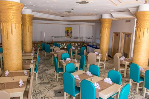 a room with tables and chairs and columns at Hotel Dreams Beach in Hammam Sousse