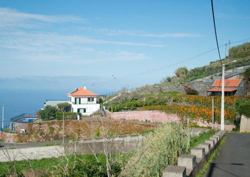 Blick auf einen Hügel mit einem Haus darauf in der Unterkunft Casa da Manta - Palheiro in Fajã da Ovelha